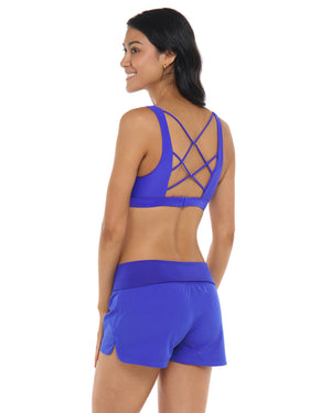 Woman wearing blue shorts and sports bra