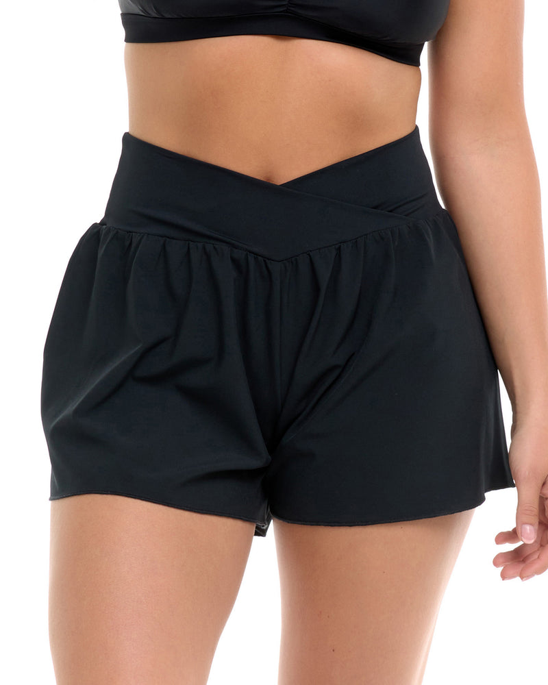  Black high-waisted athletic shorts with a crossover waistband, shown on a model against a white background. - Primary view 1